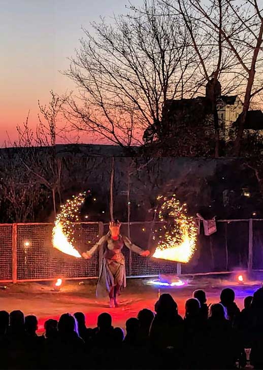 Feuershow beim Lichterfest der Grundschule Ranis in der Dämmerung, Künstler mit brennenden Fackeln vor begeisterten Zuschauern auf dem Schulhof